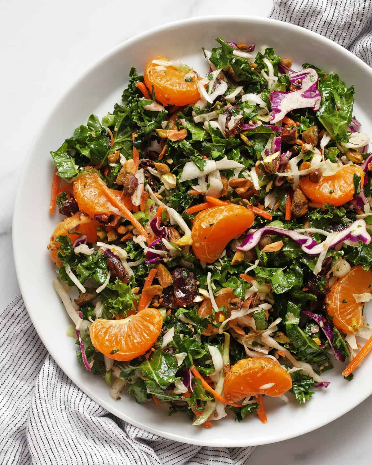 Kale salad with mandarin oranges and kale on a plate.