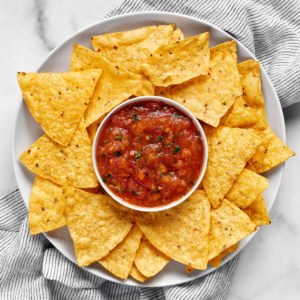 Spicy habanero salsa in a bowl with chips on a plate