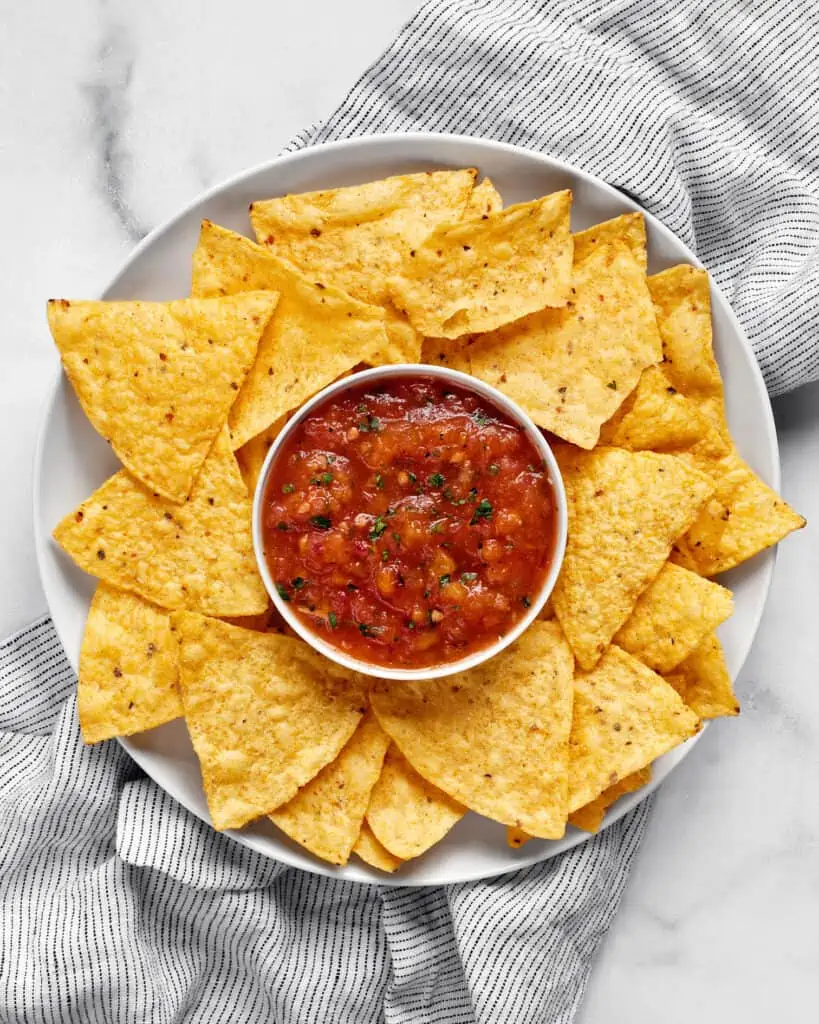 Spicy habanero salsa in a bowl with chips on a plate