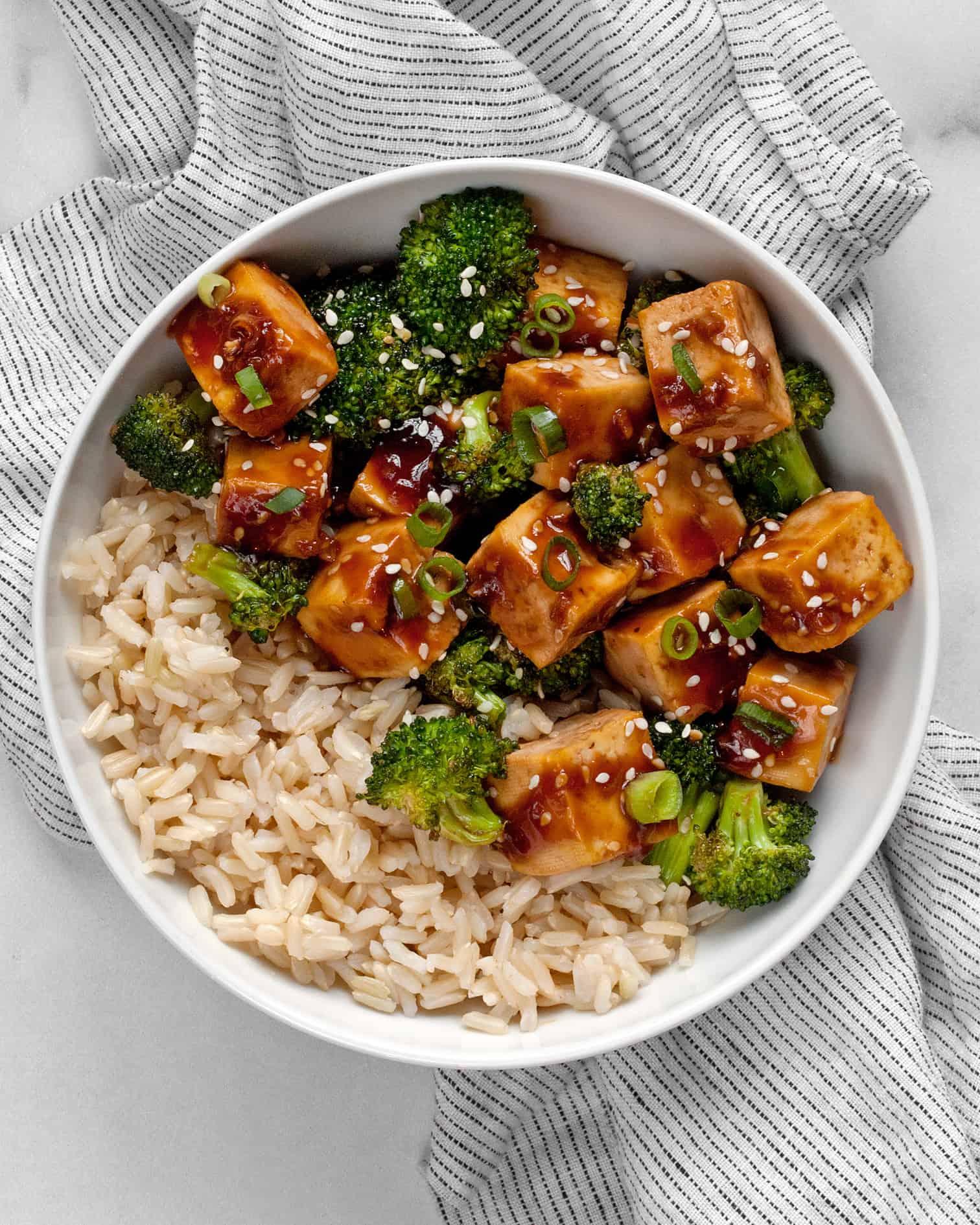 Honey garlic tofu and broccoli in a bowl with brown rice