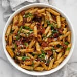 Pasta with sun dried tomatoes and arugula in a bowl