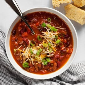 Three bean chili in a bowl with cornbread on the side.