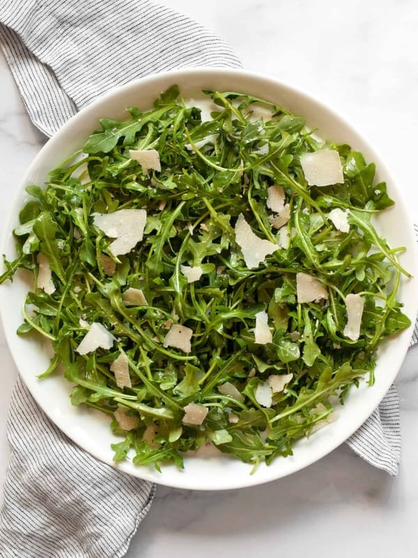 Arugula salad with parmesan on a plate.