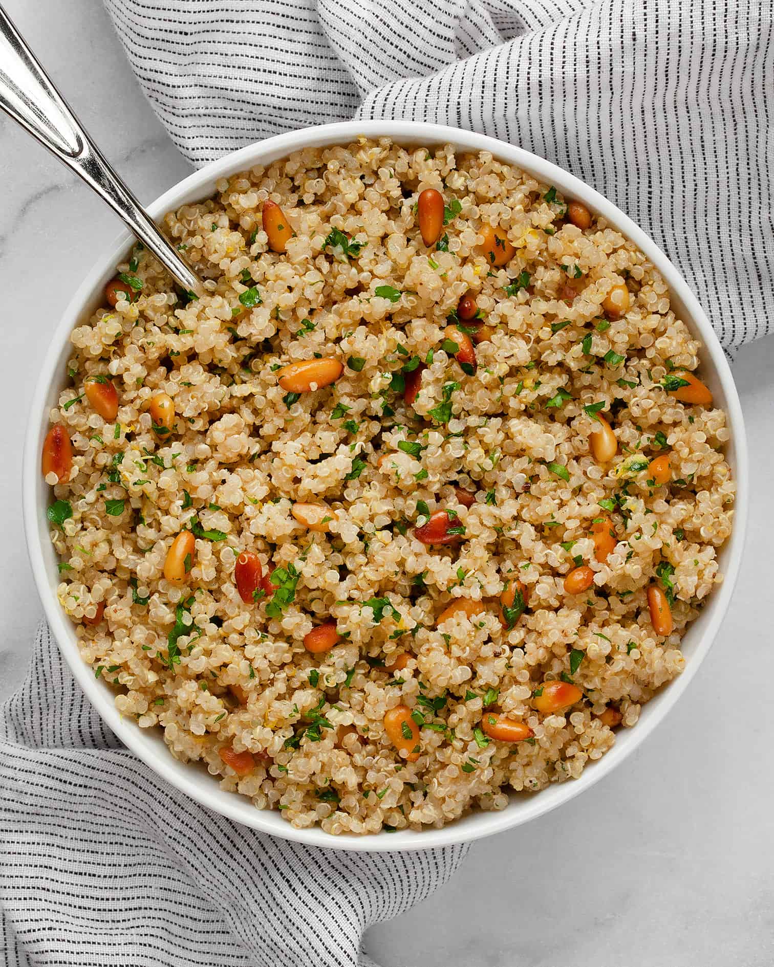 Lemon quinoa in a bowl with a serving spoon.