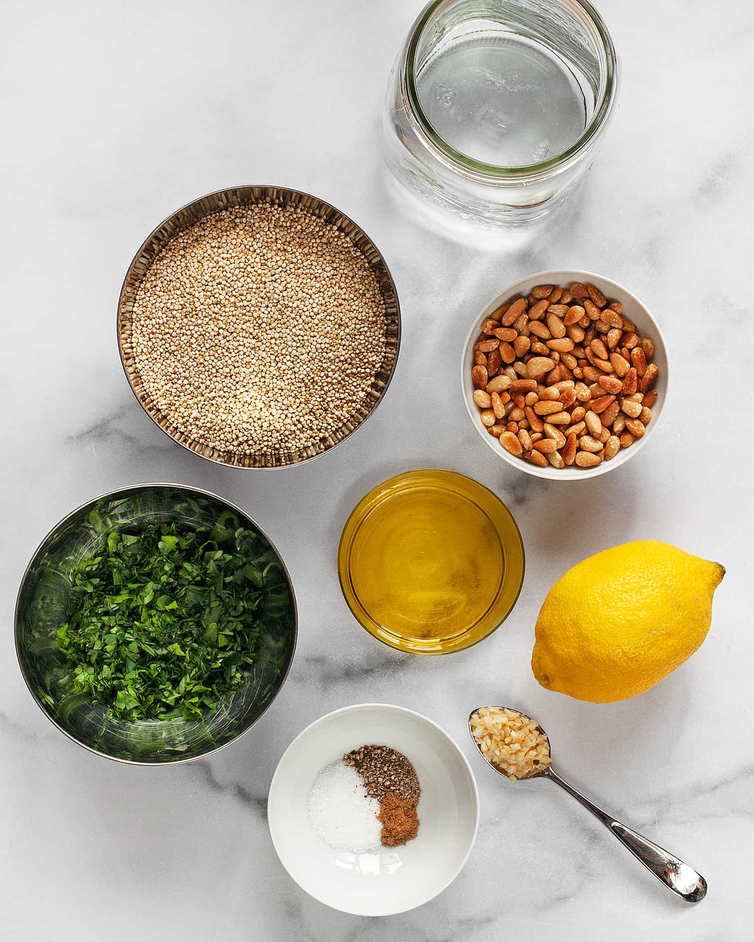 Ingredients including quinoa, lemon, parsley, pine nuts, garlic and spices.