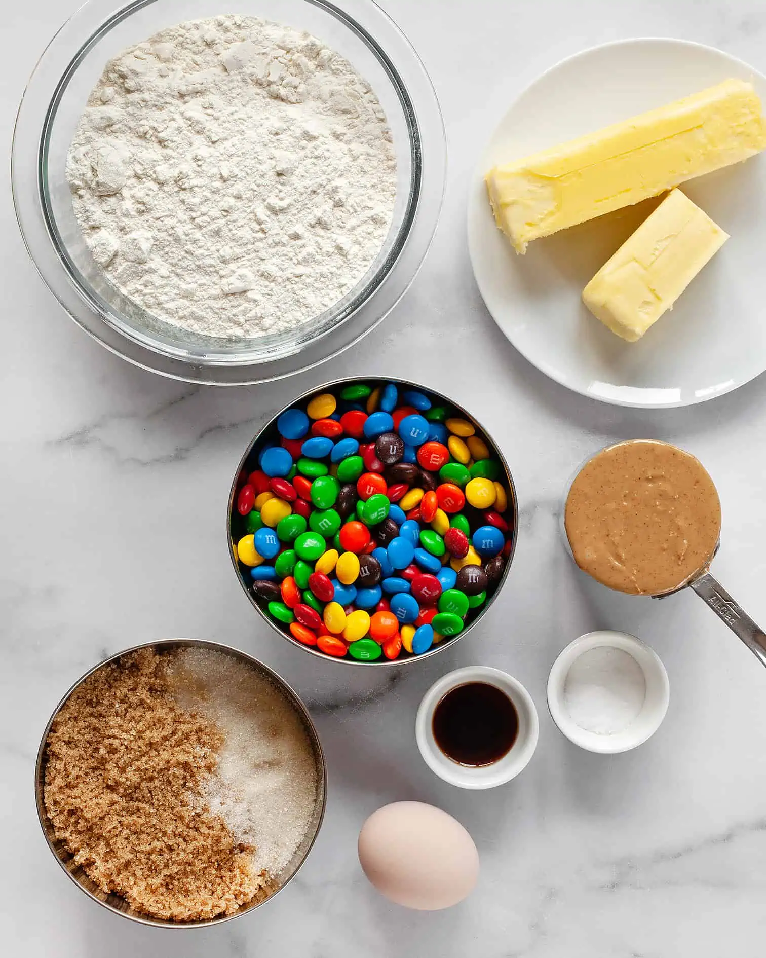 Ingredients including M&Ms, flour, peanut butter, butter, vanilla extract, egg and peanut butter 