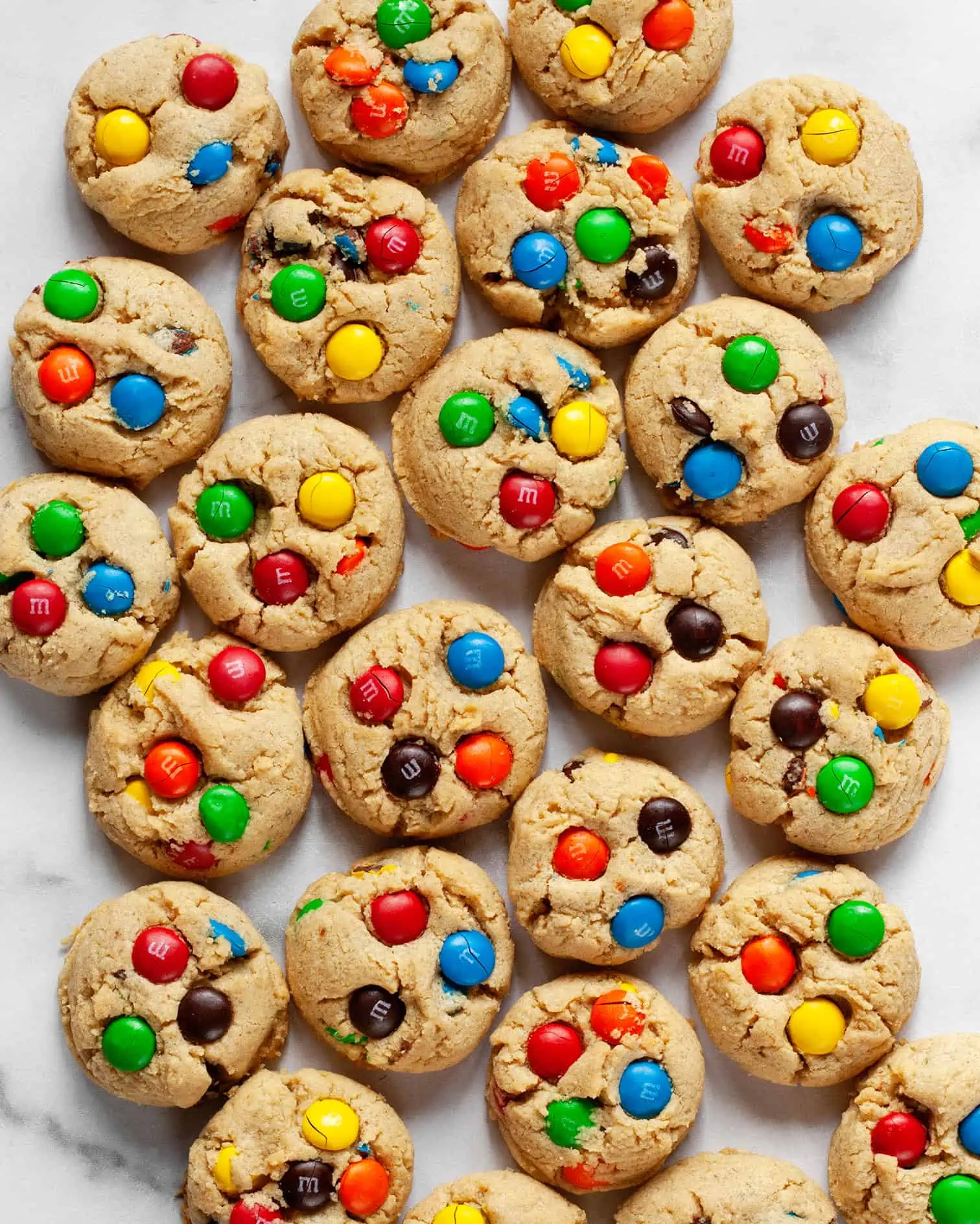 Peanut butter M&M cookies on a marble counter.