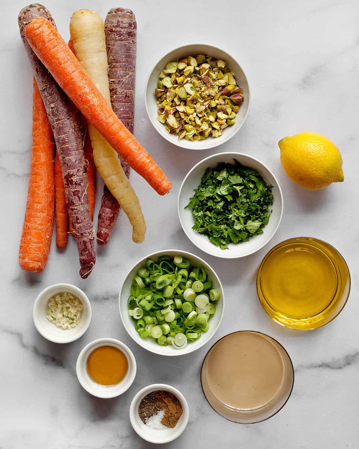 Ingredients including carrots, scallion, pistachios, lemon and olive oil.