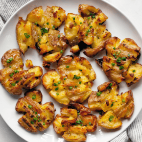 Smashed roasted potatoes on a plate.