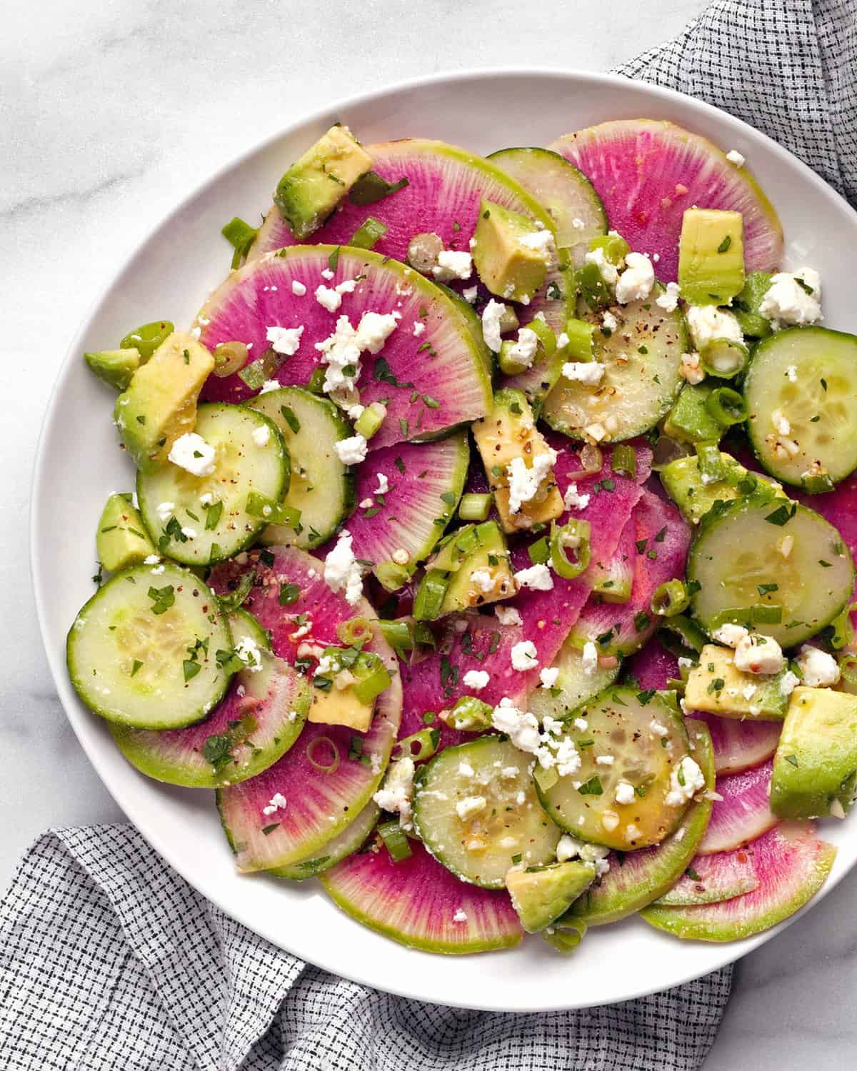 Watermelon radish cucumber salad on a plate.