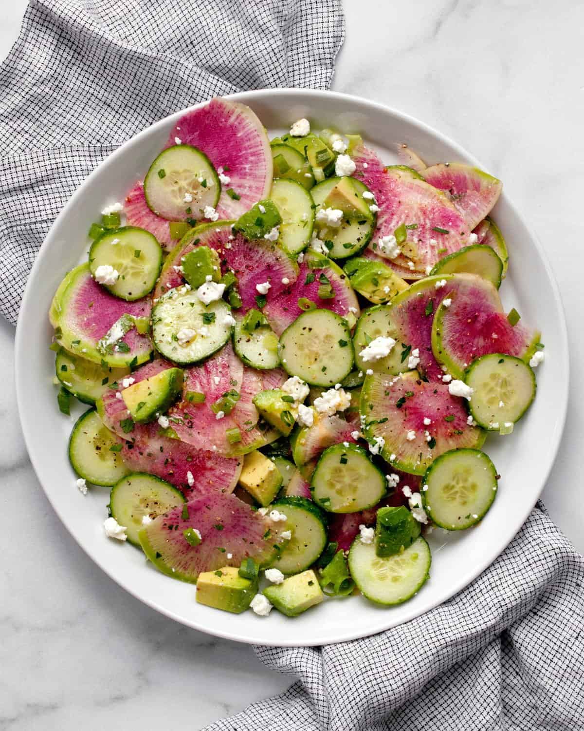 Radish salad with cucumbers and avocados on a plate.