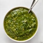 Basil pesto in a small bowl with a spoon