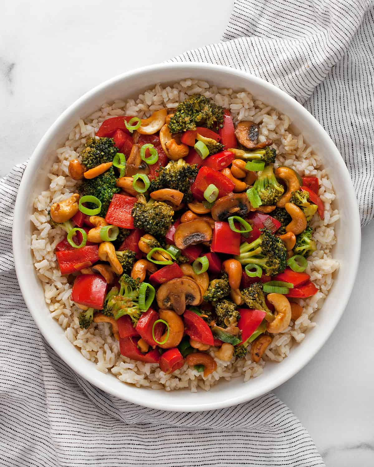Veggie stir-fry with cashews and rice in a bowl.