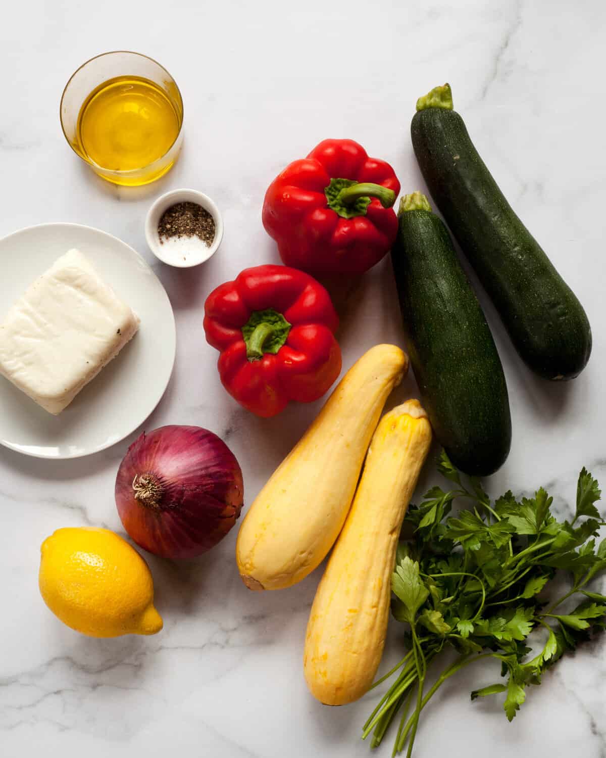 Ingredients including halloumi, zucchini, squash, peppers, onions, olive oil and lemon juice