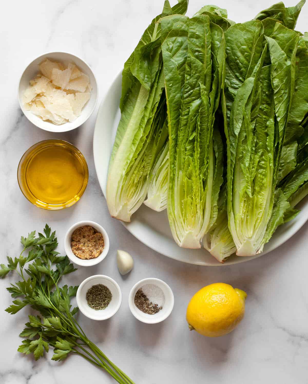 Ingredients including romaine, parmesan, olive oil, lemon, garlic, salt and pepper.