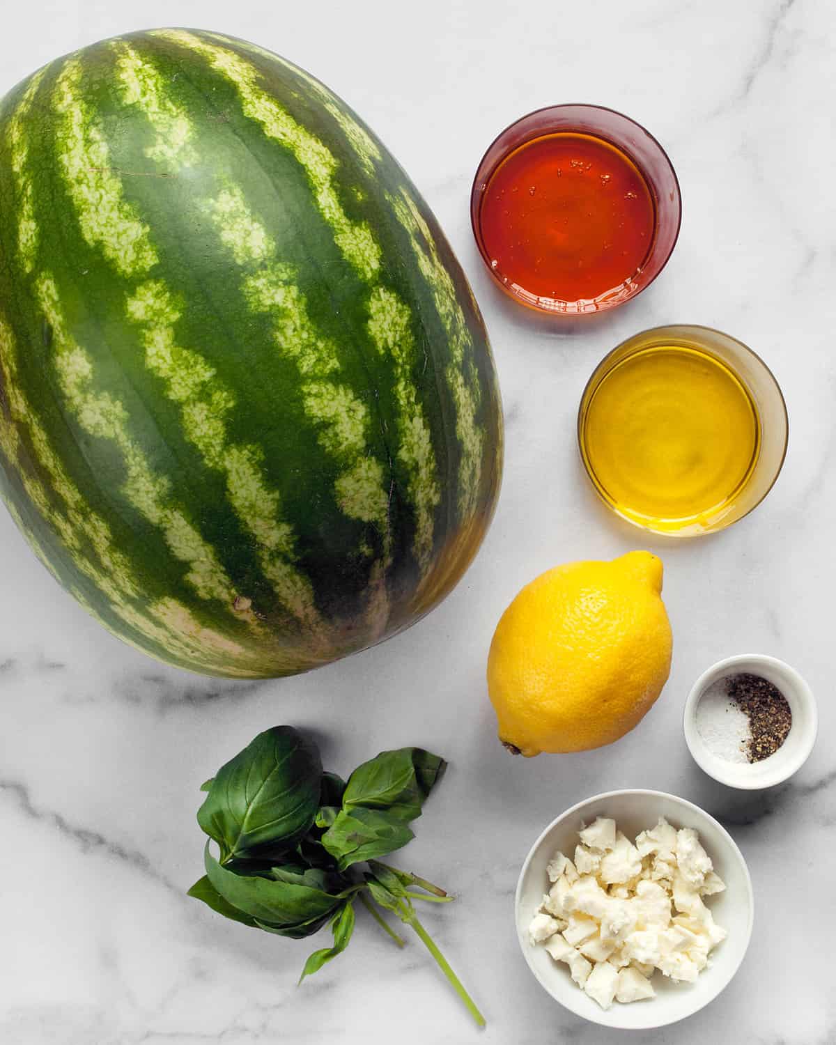 Ingredients including watermelon, honey, olive oil, feta and basil