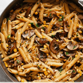 Mushroom corn penne pasta in a skillet.