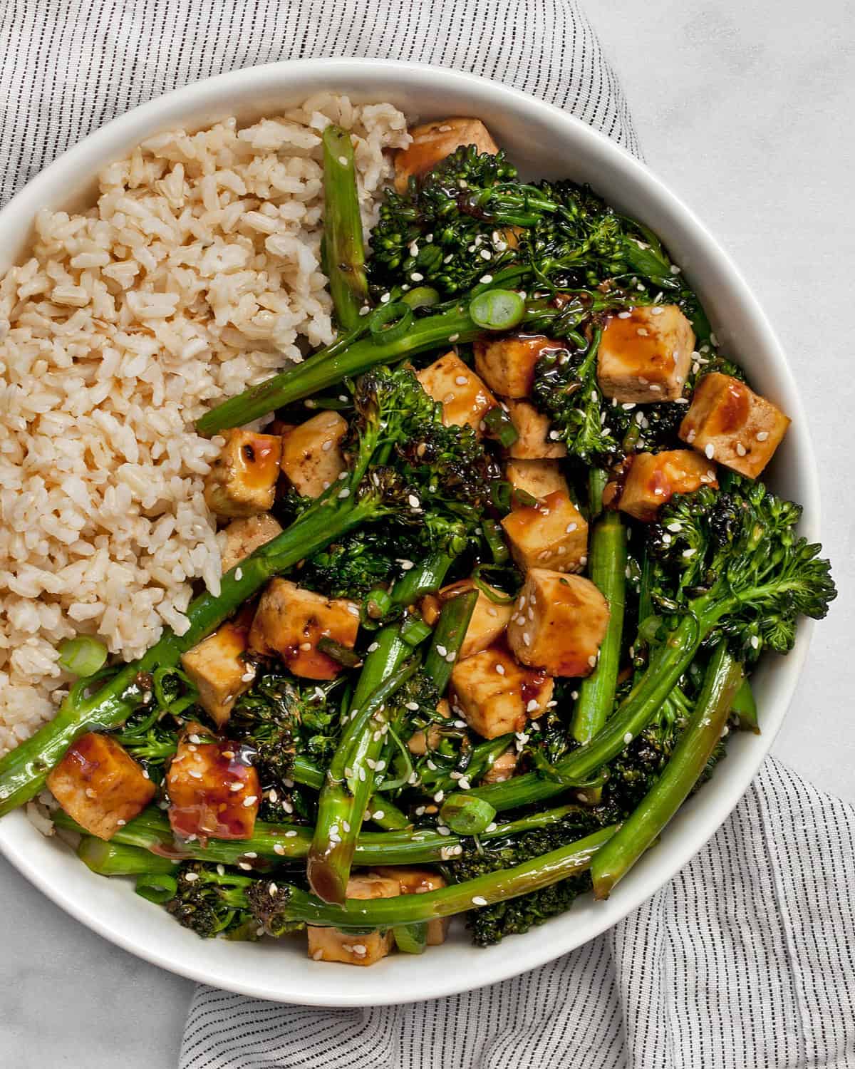 Teriyaki tofu with broccolini and brown rice in a bowl.