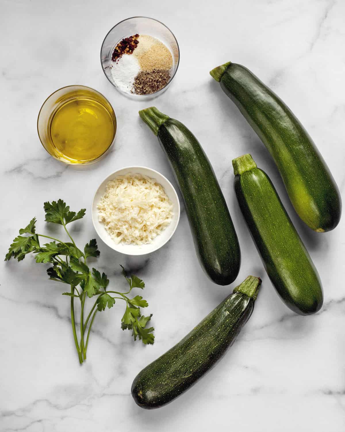 Ingredients including zucchini, spices, parmesan, olive oil and parsley.