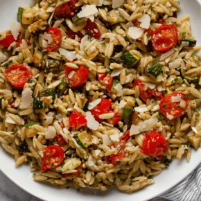 Roasted tomato zucchini orzo on a plate.