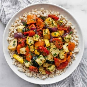 Roasted Mediterranean vegetables and halloumi with barley on a plate.