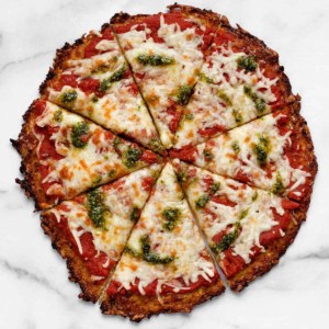 Cauliflower pizza with pesto and tomato sauce.