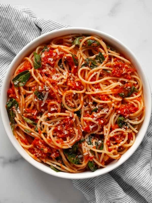 Fresh tomato pasta with basil in a bowl.