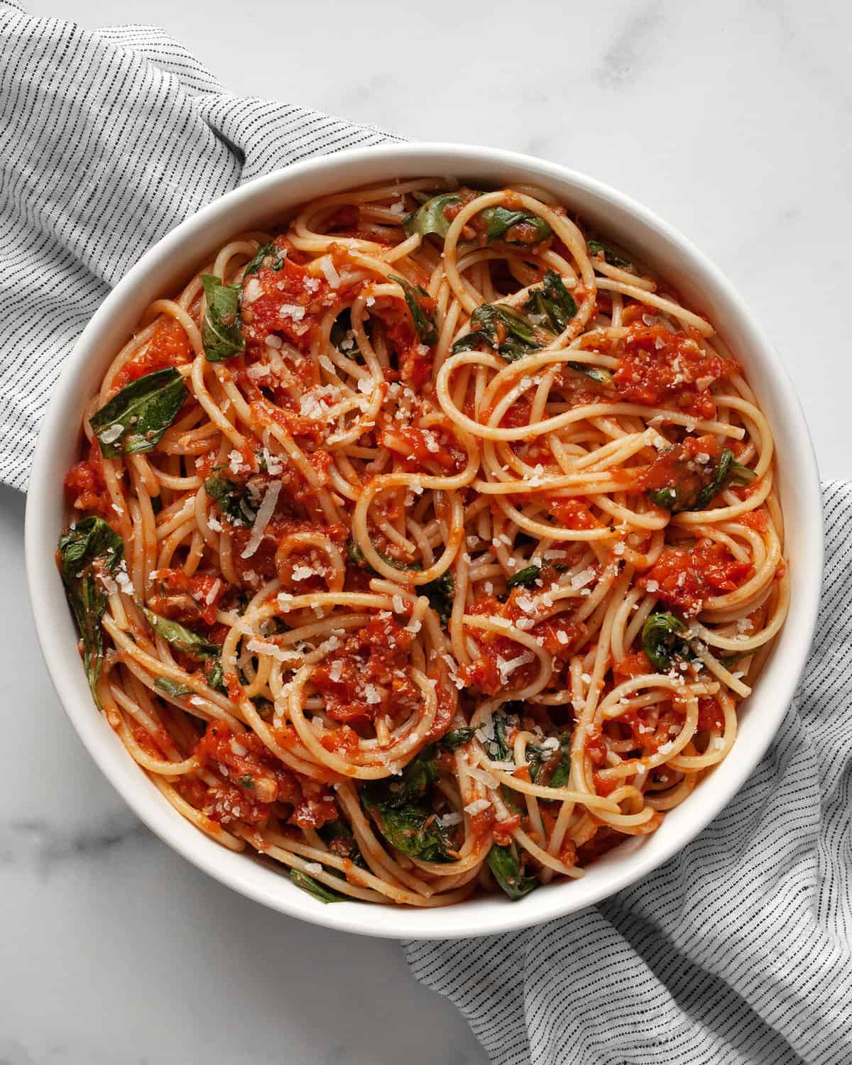 Fresh tomato pasta with basil in a bowl.