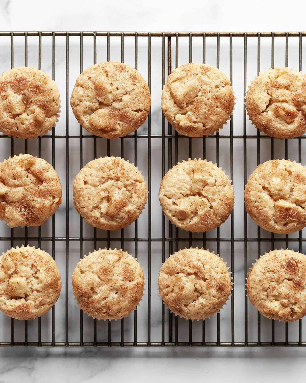Cinnamon apple muffins cooling on a wire rack.