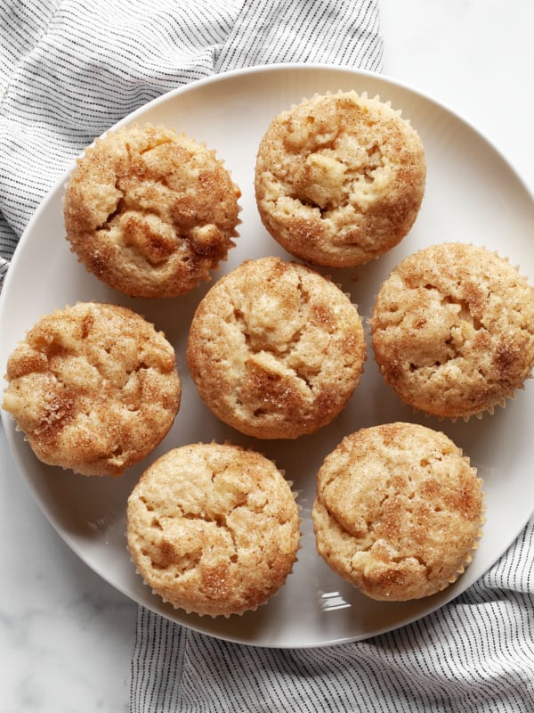 Seven apple cinnamon muffins on a plate.