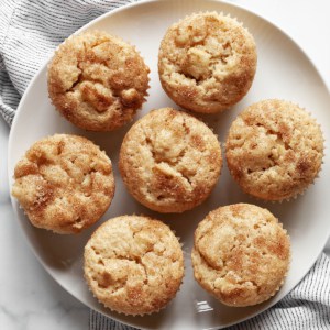 Seven apple muffins on a plate.
