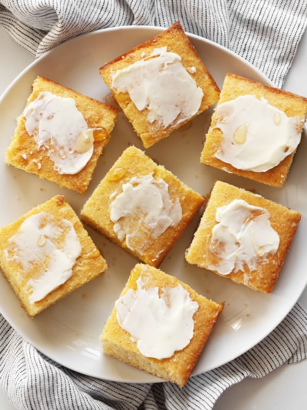 Cornbread cut into squares with the tops spread with butter and drizzled with honey.