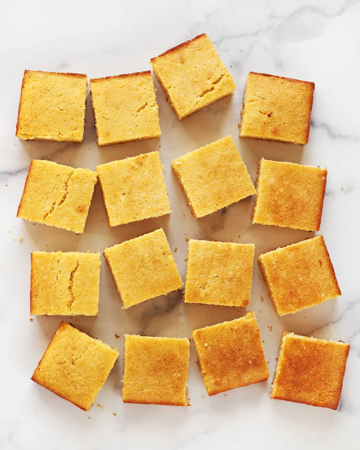Cornbread cut into squares and arranged in rows.