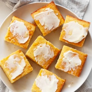 Cornbread cut into squares with the tops spread with butter and drizzled with honey.