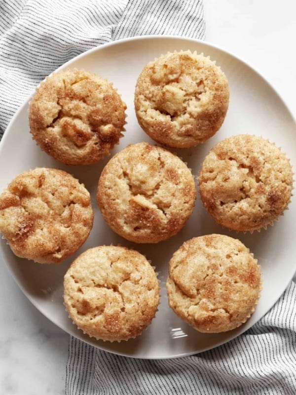 Seven apple cinnamon muffins on a plate.