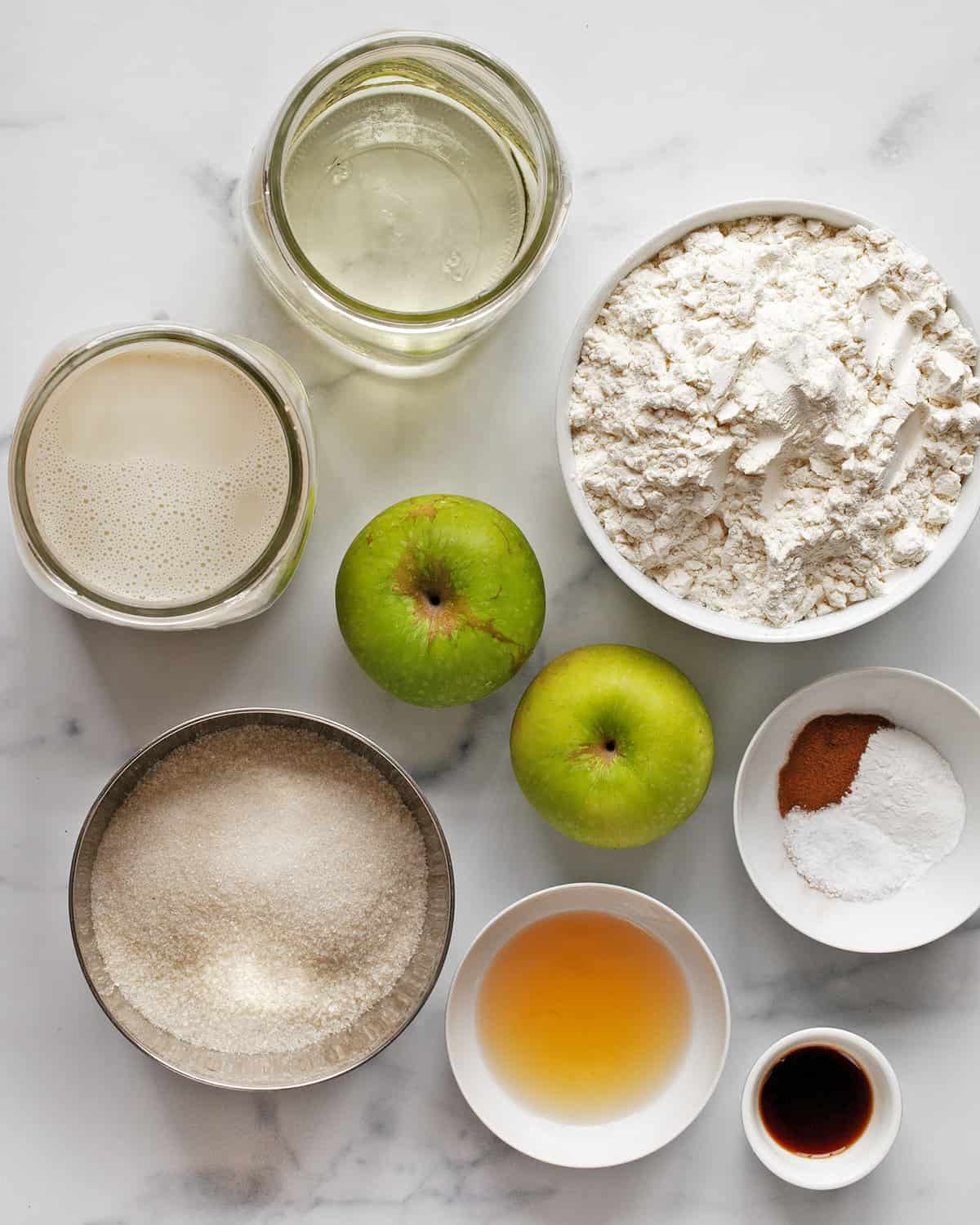 Ingredients including, flour, cinnamon, apples, sugar, baking powder, salt, oil, milk, vinegar and vanilla extract.