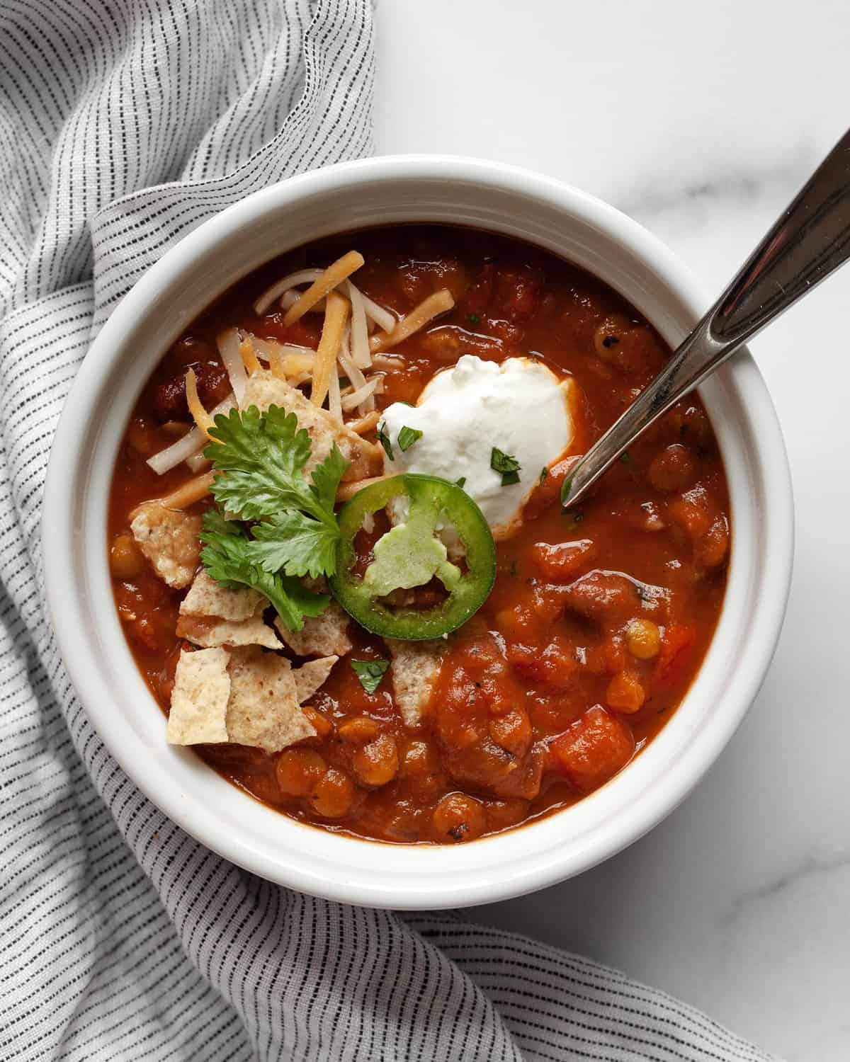 Pumpkin chili with toppings in a bowl.