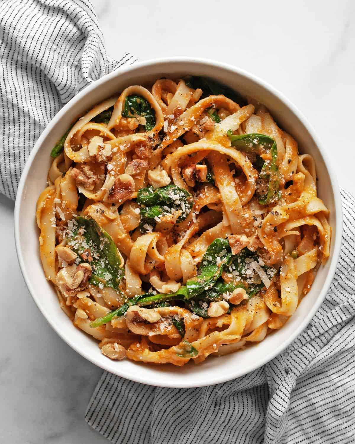 Pumpkin pasta with spinach on a plate.