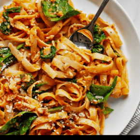 Pumpkin pasta with baby spinach on a plate.