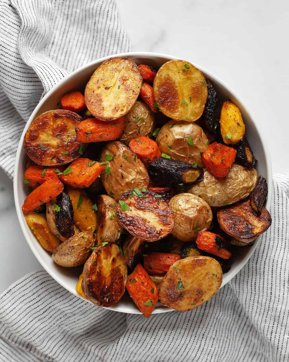 Roasted potatoes and carrots in a bowl.