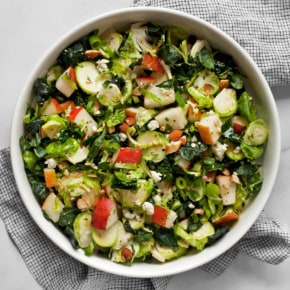 Kale brussels sprout pear salad in a bowl.