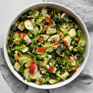 Kale brussels sprout pear salad in a bowl.