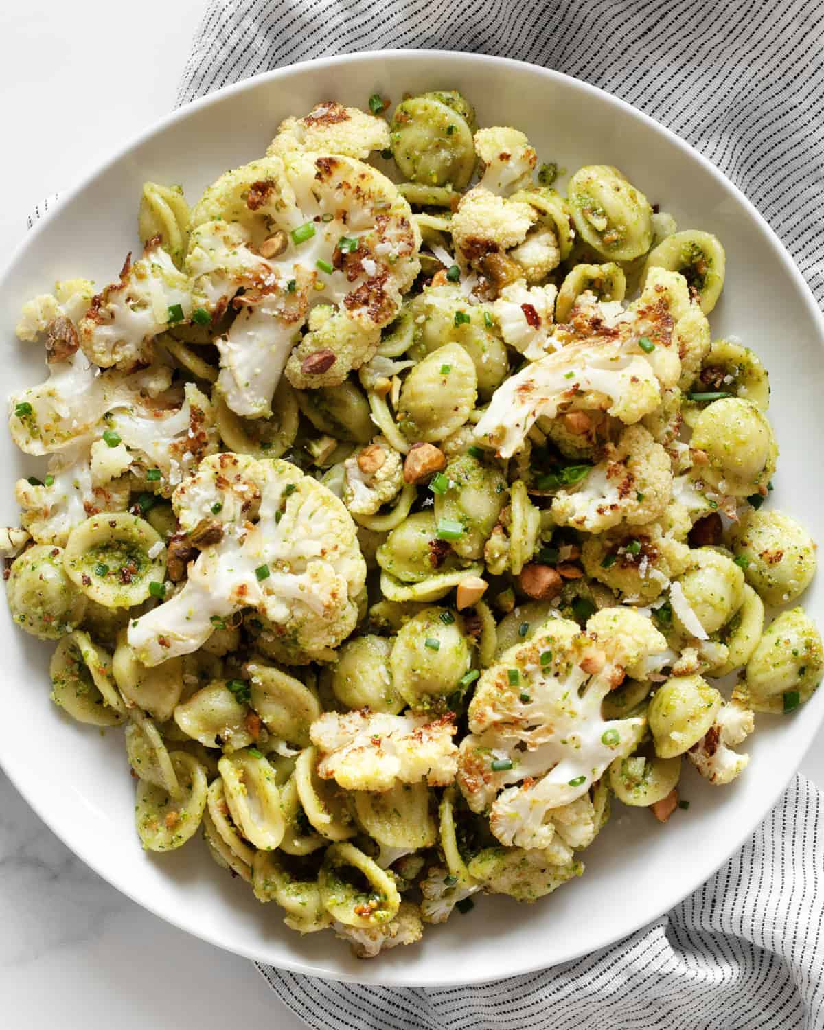 Roasted cauliflower pasta with spinach pesto on a plate.