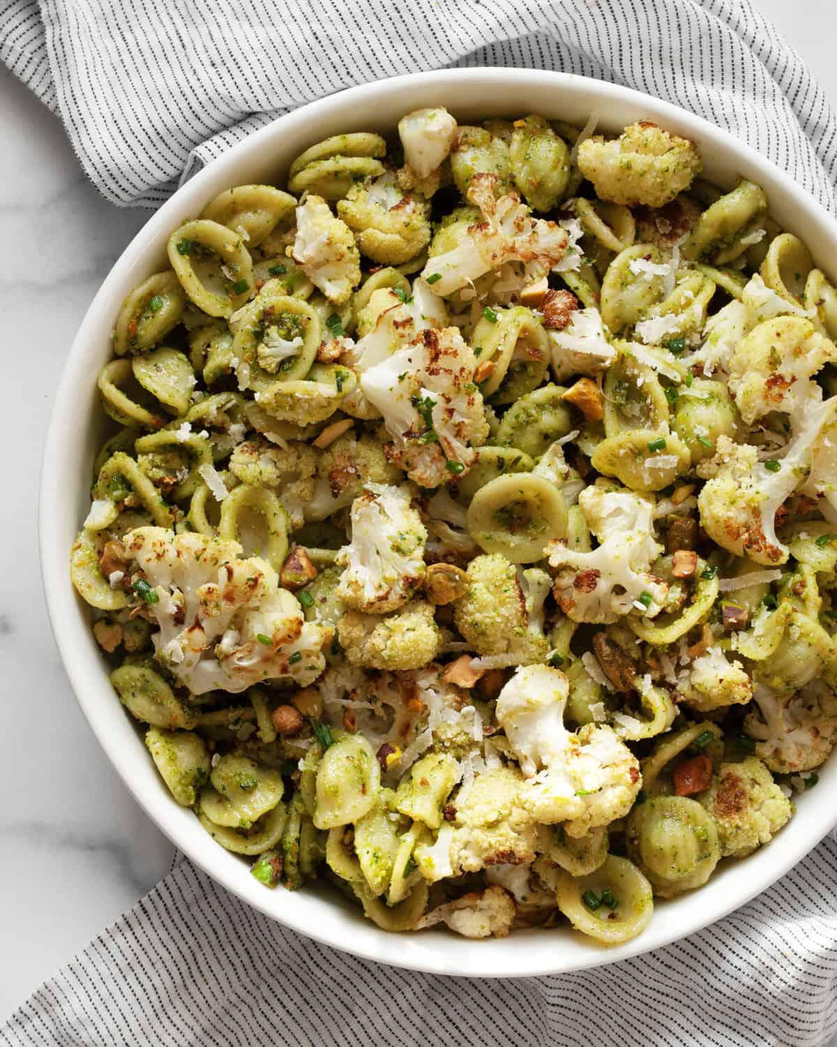 Roasted cauliflower pasta with spinach pesto in a bowl.