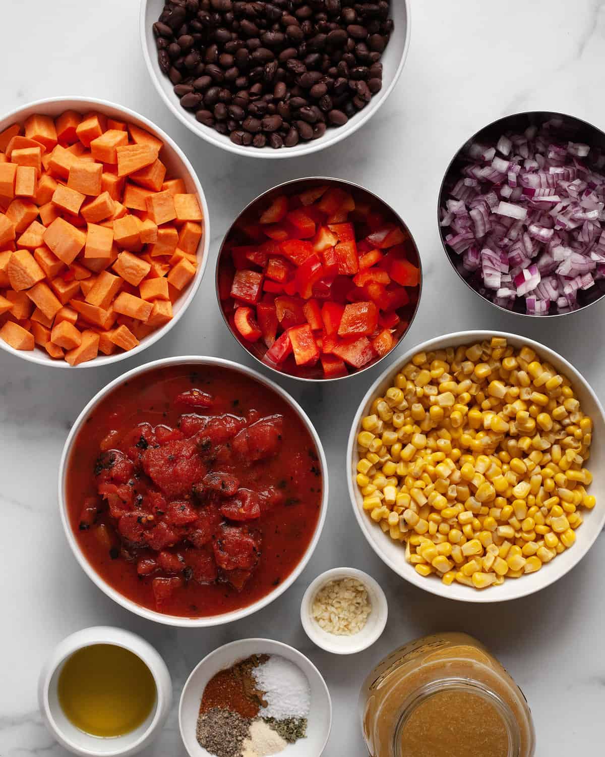 Ingredients including sweet potatoes, black beans, corn, red peppers, onions, garlic, vegetable broth and dried seasonings.