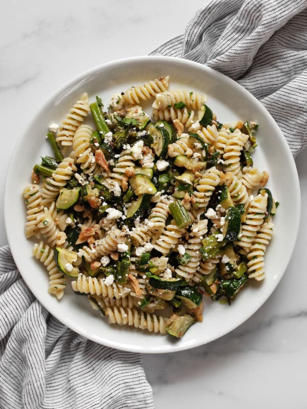 Roasted broccolini and zucchini pasta salad on a plate.