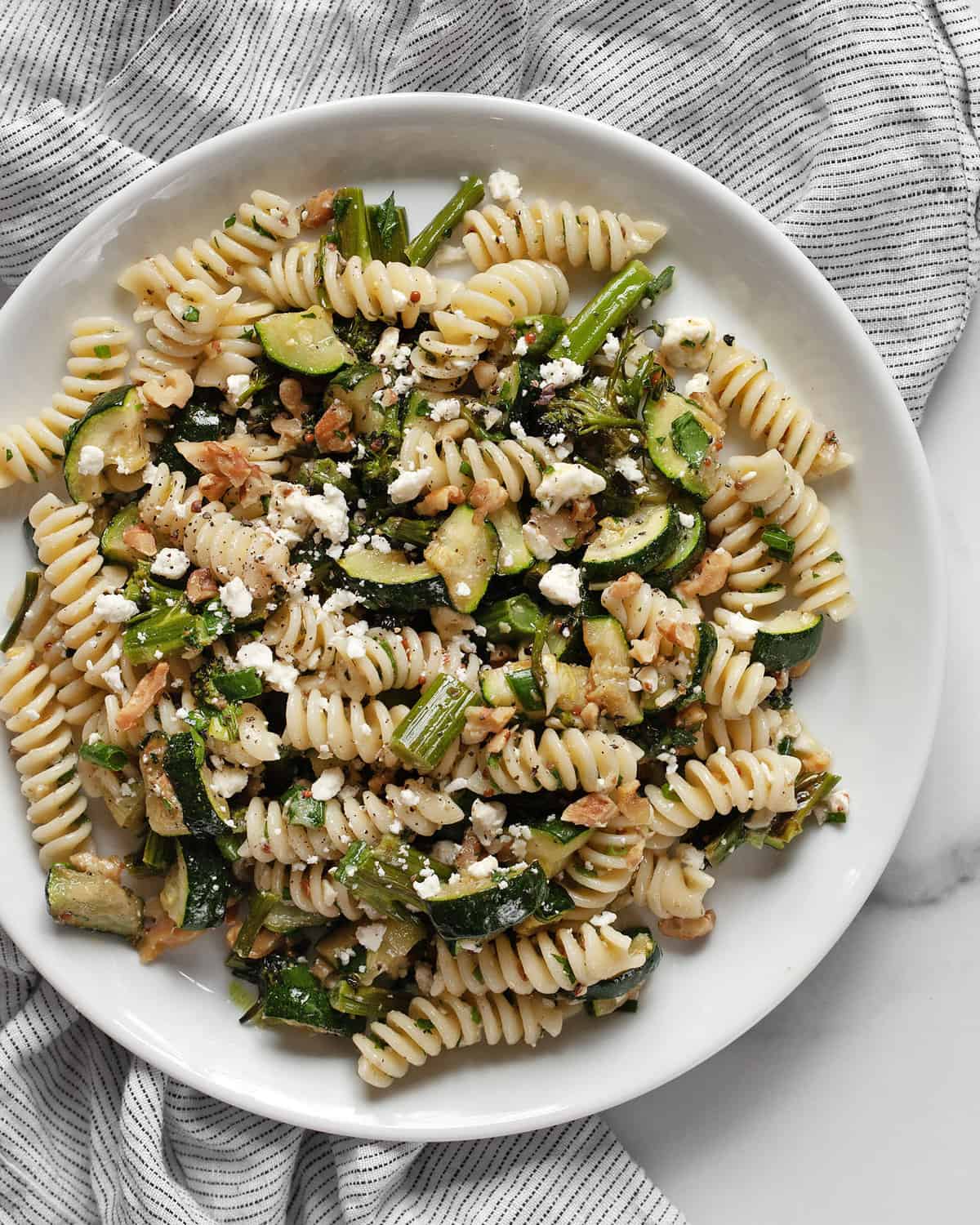 Pasta salad with roasted broccolini and zucchini on a plate.