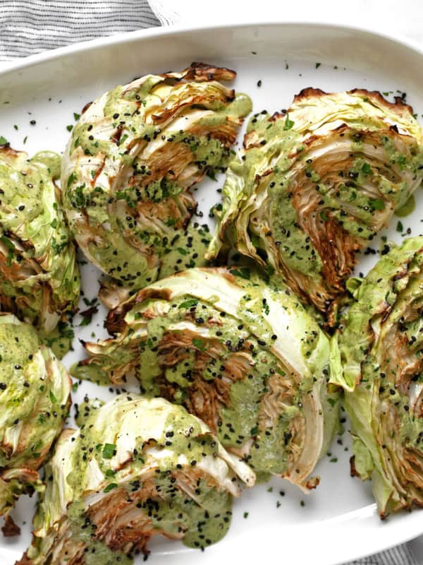 Roasted cabbage wedges on an oval platter.
