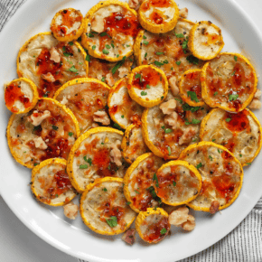Parmesan roasted yellow squash drizzled with hot honey on a plate.