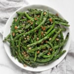 Grilled green beans with almond gremolata on a plate.